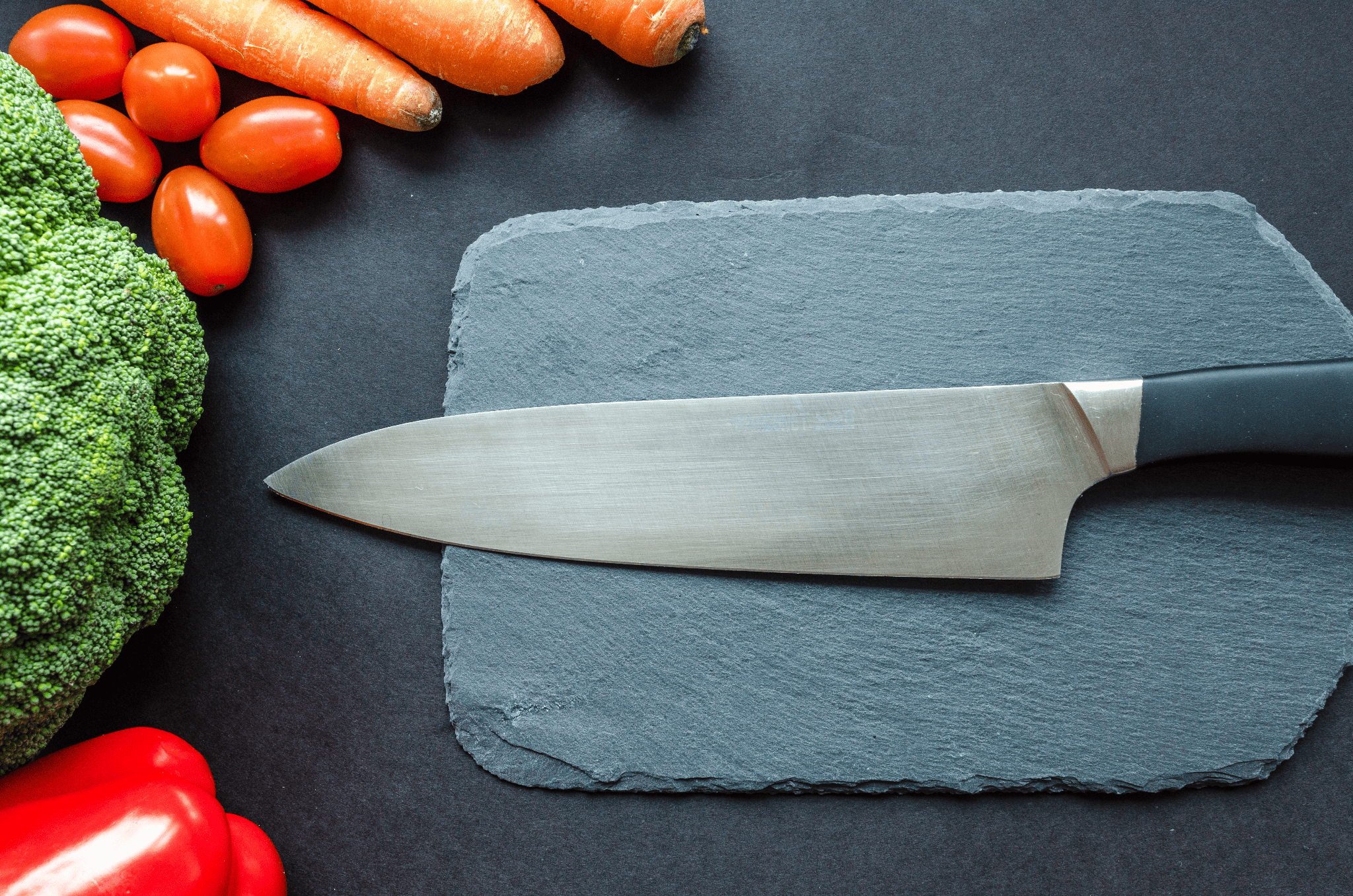 chef's knife on a slate cutting board