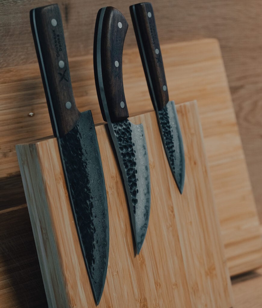 3 damascus chef's knives on a magnetic wood stand